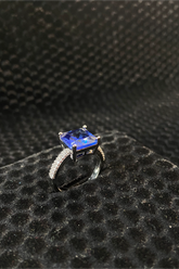 Ring with a blue gemstone on a textured black surface