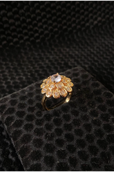 Gold ring with gemstones on a black textured surface
