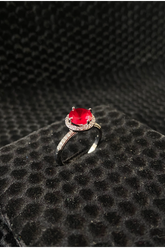 Ring with a red gemstone on a textured black surface