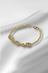 Gold bracelet with clear stones on a white satin background
