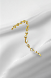 Gold bracelet with heart-shaped stones on a white satin background