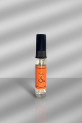 Small perfume bottle with an orange label on a gray background