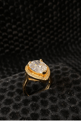 Gold ring with a large diamond on a black textured background