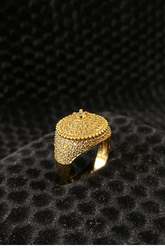 Gold ring with intricate design on a black textured background
