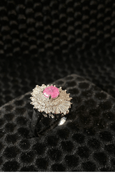 Silver ring with a pink gemstone on a black textured background