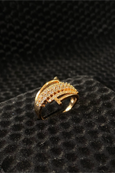 Gold ring with diamond accents on a black textured surface