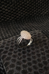 Silver ring with a textured design on a black textured surface