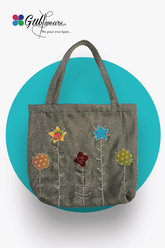 A gray hand work tote bag with a brand logo at the top, adorned with colorful floral and star patterns on the front.