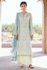 Woman wearing a light blue and white traditional outfit with a matching dupatta, standing in a scenic outdoor setting.