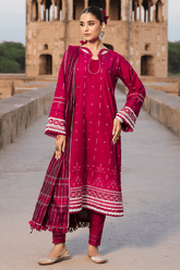 Woman in a red traditional outfit standing in front of a historical building.