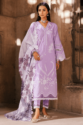 Woman wearing a lavender traditional outfit with white embroidery in a warm-toned interior setting.