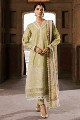 Woman wearing a green traditional outfit with a matching dupatta in an indoor setting.