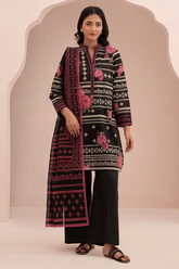 Woman wearing a black and pink embroidered traditional outfit against a beige background