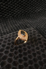 Gold ring with gray gemstones on a black textured surface