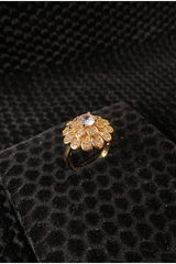 Gold ring with gemstones on a black textured surface