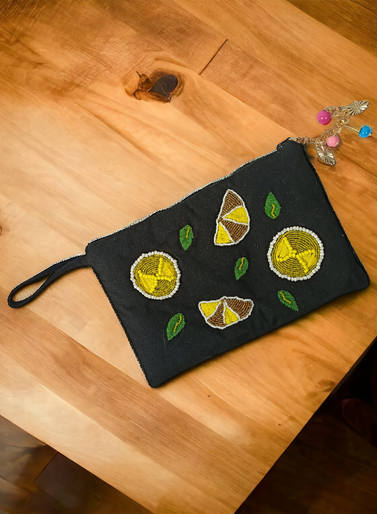Elegant Black Pearl Lemon Embellished Clutch Bag placed on wooden tables.