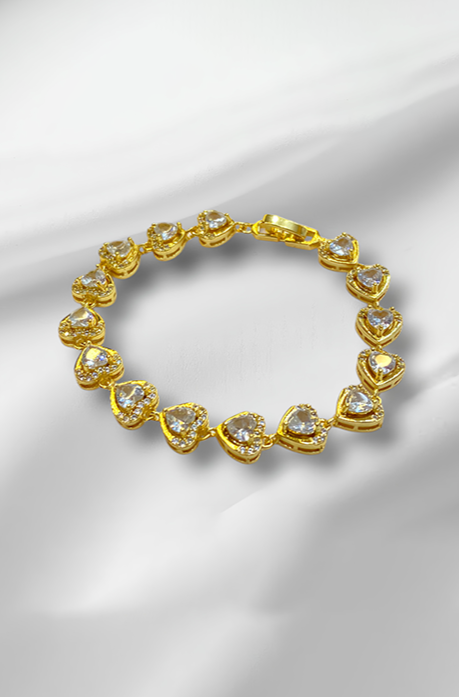 Golden bracelet with heart-shaped gemstones on a satin background