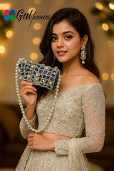 An off-white clutch bag with pearl accents and intricate Gotta work, holding a beautiful girl.