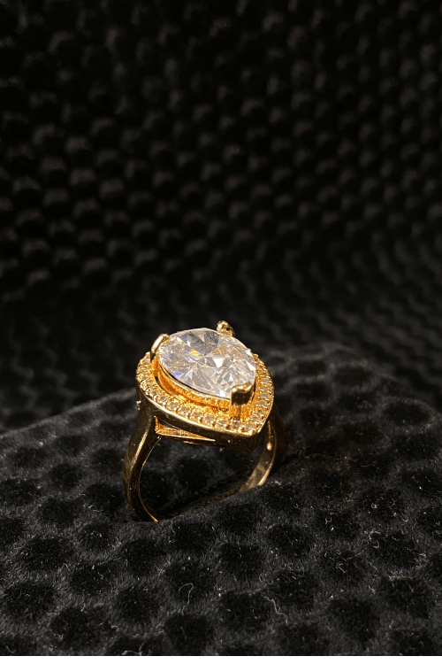Gold ring with a large diamond on a black textured background