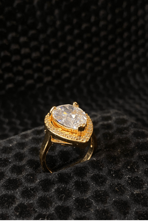 Gold ring with a large diamond on a black textured background