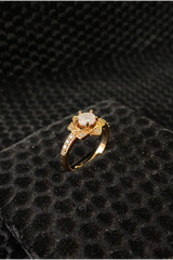 Gold ring with a diamond on a black textured surface