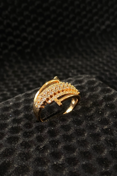 Gold ring with diamond accents on a black textured surface