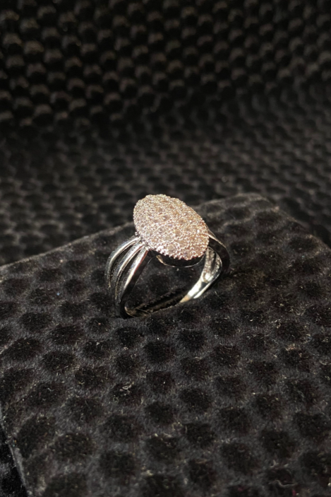 Silver ring with a textured design on a black textured surface