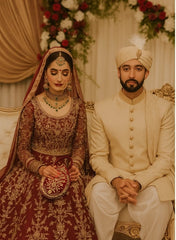Traditional wedding attire with intricate designs and jewelry and bride holding a Elegant Drop Shape Clutch Bag.