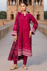 Woman in a red traditional outfit standing in front of a historical building.
