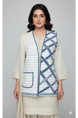 Woman wearing a white and blue patterned jacket with a plain background