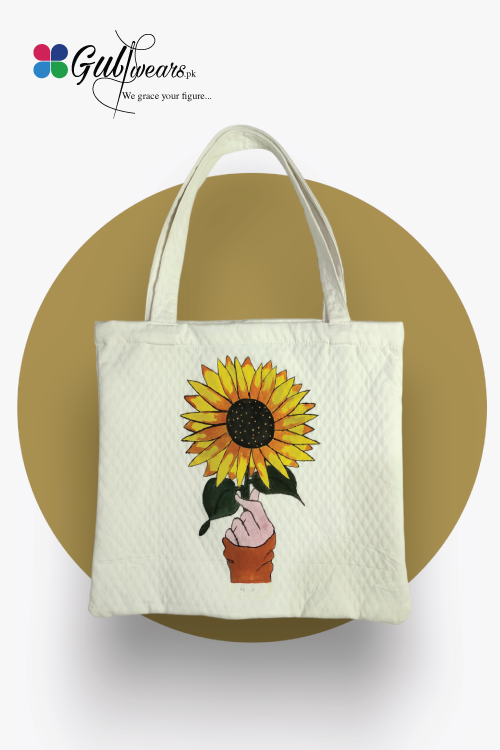 White painted tote bag with a sunflower design and a handle, displayed on a golden background.