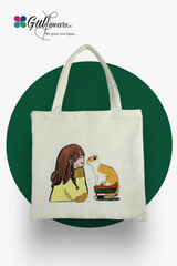 A white painted tote bag with a graphic print of a girl reading to a cat, and the brand logo 'Gulwears' at the top.