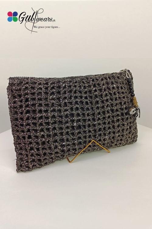 A black and silver fabric clutch bag with a floral pattern, displayed on a stand.