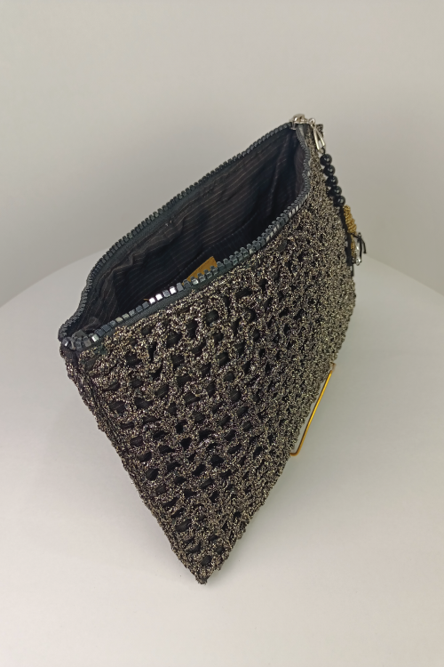 A black and silver fabric clutch bag with a floral pattern, displayed on a stand.